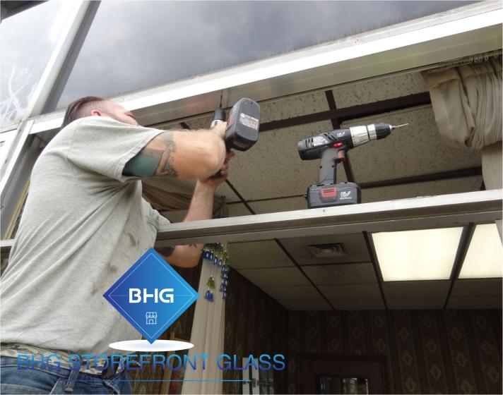 Commercial window installation by a technician on a ladder